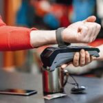 Man_using_handwatch_on_the_cash_register_for_buying_goods_at_the_sports_shop,_close-up_view_with_no_face